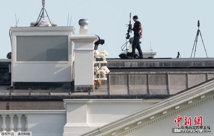 资料图：当地时间5月30日，美国华盛顿，美国特情局反狙击队的一名队员行走在白宫的房顶上。